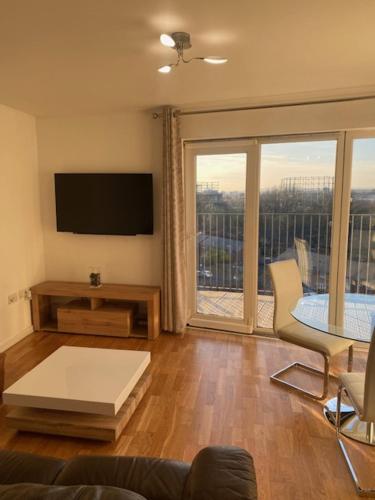 a living room with a television and a table and a couch at Eaglet 2 Bedroom Luxury Home near Etihad Staduim in Manchester