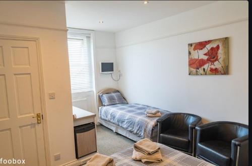 a bedroom with a bed and a table and two chairs at Weymouth Bay Hotel in Weymouth