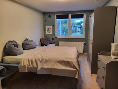 a bedroom with a bed and a window at Das Lupinchen in Neuss