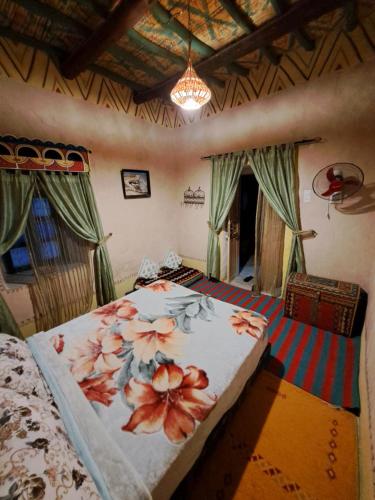 Un dormitorio con una cama con flores. en DAR JOUD, en Tabourakht