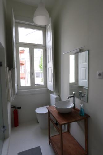 a bathroom with a sink and a toilet and a window at Rustic Silent Ensuites - Shared Kitchen - Self check in in Porto