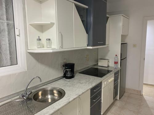una cucina con lavandino e piano di lavoro di Apartamento cinta 3 habitaciones a Siviglia