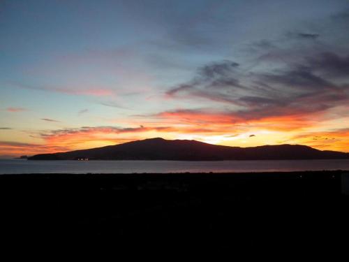 a sunset over a body of water with a mountain at Moradia Familiar NovaVista - T3 in Madalena