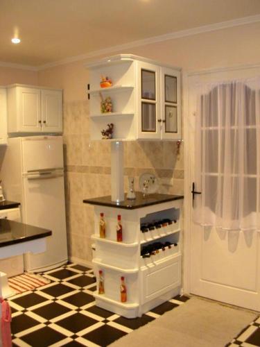 a kitchen with a refrigerator and a shelf with wine bottles at Moradia Familiar NovaVista - T3 in Madalena
