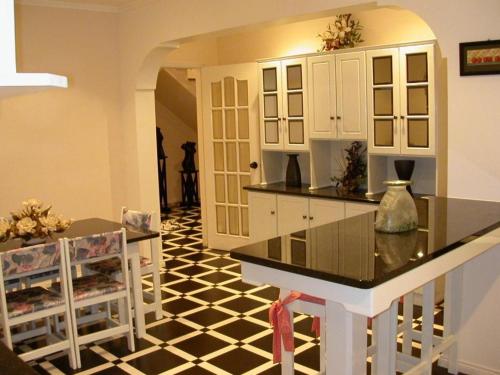 uma cozinha com piso em azulejo preto e branco em Moradia Familiar NovaVista - T3 em Madalena