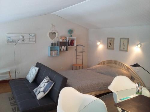 ein Schlafzimmer mit einem Bett, einem Sofa und Stühlen in der Unterkunft Appartement Saint-Martin-de-Ré, 3 pièces, 4 personnes - FR-1-544-10 in Saint-Martin-de-Ré