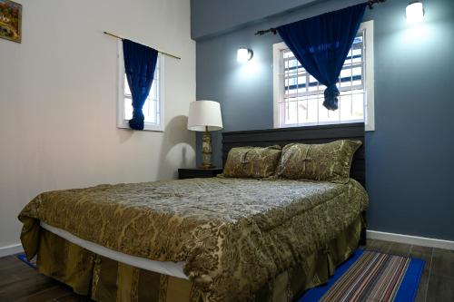 Schlafzimmer mit einem Bett mit blauen Wänden und Fenstern in der Unterkunft La Vue in Anse La Raye