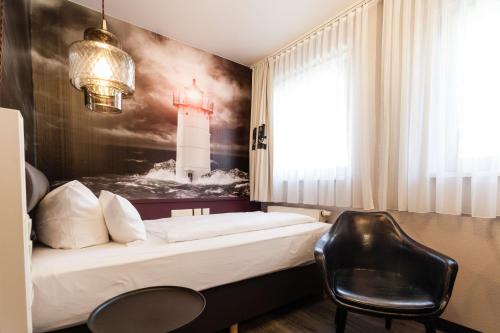 ニュルンベルクにあるベストウエスタン ホテル ニュルンベルク アム ハウプトバーンホフのベッドと椅子付きのホテルルーム