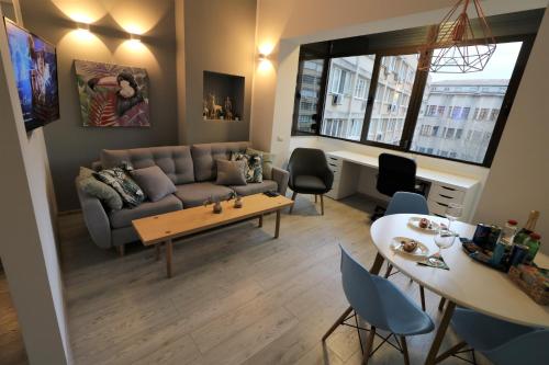un soggiorno con divano e tavolo di Cozy Novotel Studio - Free Minibar - Quiet & Peace a Bucarest