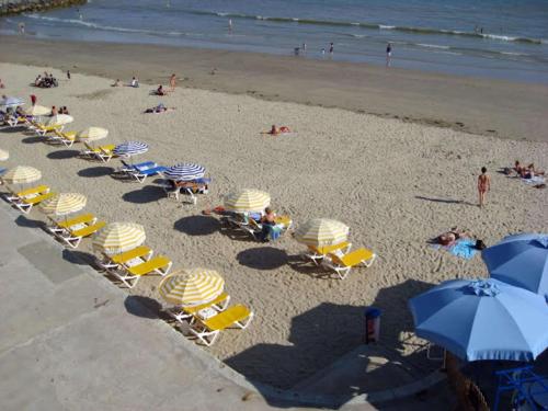 einen Blick über den Strand mit Stühlen und Sonnenschirmen in der Unterkunft Best Western Hôtel Royan Océan in Royan