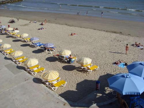 - une vue sur la plage dotée de chaises et de parasols dans l'établissement Best Western Hôtel Royan Océan, à Royan