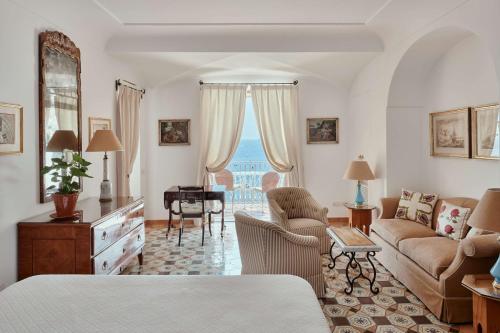 a living room with a couch and a table at Le Sirenuse in Positano