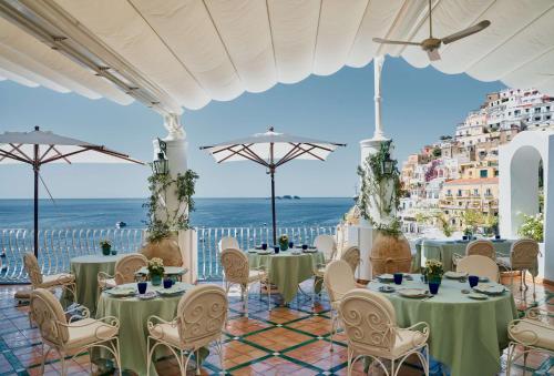 a restaurant with tables and chairs and a view of the ocean at Le Sirenuse in Positano