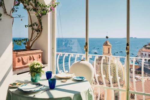 a table in a room with a view of the ocean at Le Sirenuse in Positano