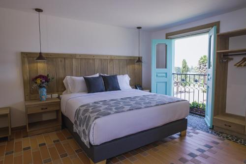ein Schlafzimmer mit einem großen Bett und einem Balkon in der Unterkunft Alfahar Hotel in Carmen de Viboral