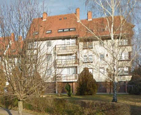 duży biały budynek z czerwonym dachem w obiekcie Kalmár Apartman w mieście Veszprém