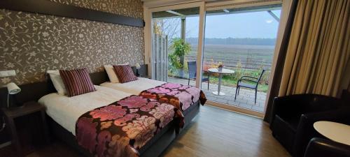 a hotel room with two beds and a balcony at B&B Hotel De Vrije Vogel in Elsloo