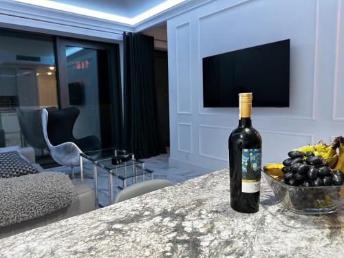 Eine Flasche Wein stand mit einer Obstschale auf einem Tisch. in der Unterkunft Hanza Tower Apartament Times Square in Stettin