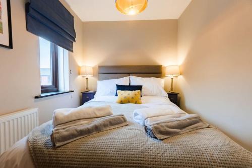 a bedroom with a large bed with two pillows on it at Hullidays》Marina Town House in Hull