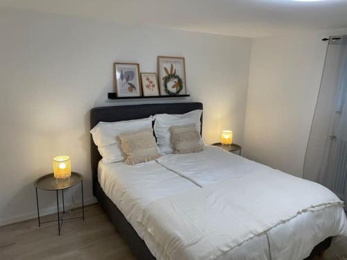 博倫多夫的住宿－Gemütliche&Moderne Ferienwohnung Nähe Trier & Luxemburg，一间卧室配有一张带两张桌子和蜡烛的床。