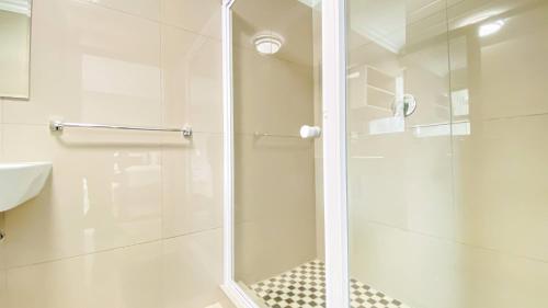 La salle de bains est pourvue d'une douche avec une porte en verre. dans l'établissement Midrand Air B and B House, à Midrand