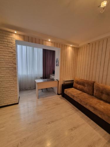uma sala de estar com um sofá e uma mesa em Сдам ПОСУТОЧНО уютную квартиру на Марсельской em Kryzhanivka