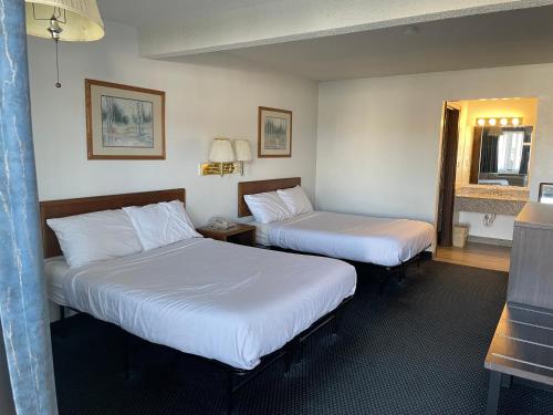 a hotel room with two beds and a mirror at Landmark Inn in Osawatomie
