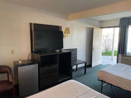 a hotel room with a large flat screen tv at Landmark Inn in Osawatomie