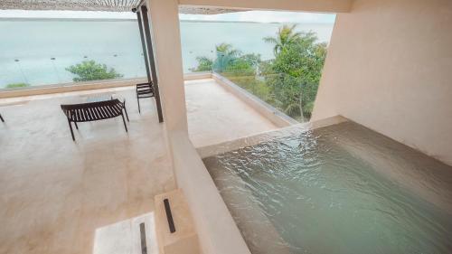 Habitación con piscina de agua, mesa y sillas. en MBH Maya Bacalar Hotel Boutique en Bacalar