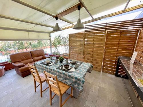 a patio with a table and chairs and a couch at Bilocale con terrazza privata - Metro M1 to City Center in Sesto San Giovanni
