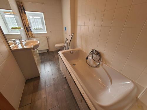 een badkamer met een bad, een toilet en een wastafel bij Gîte Taintrux, 5 pièces, 10 personnes - FR-1-589-232 in Taintrux
