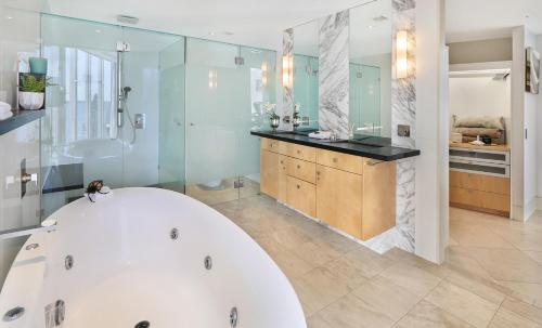 a large bathroom with a tub and a sink at Oceans Mooloolaba in Mooloolaba