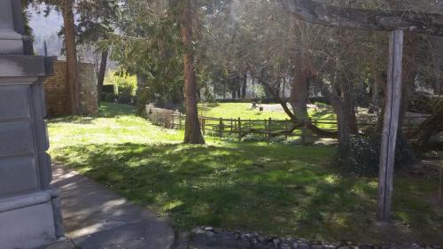 a yard with a fence and trees and grass at Villa Pitiana in Donnini