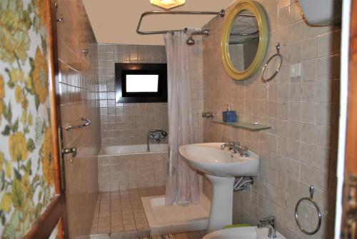 een badkamer met een wastafel, een douche en een toilet bij Villa Bice with sea viewpool in Castellonorato