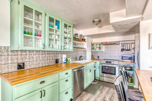 a kitchen with green cabinets and a wooden counter top at Cake by the Ocean in Lincoln City