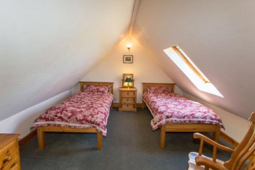 um quarto no sótão com 2 camas num sótão em The Steading em Corrie