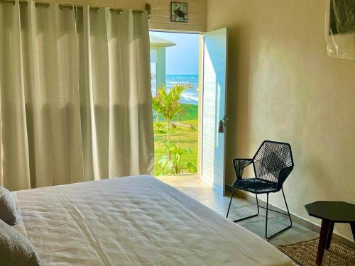 a bedroom with a bed and a chair and a window at MiKiPi Hotel Boutique in La Vigueta