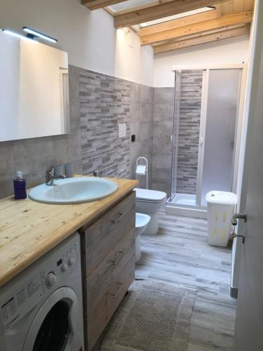 een badkamer met een wastafel en een wasmachine bij Balai house in Porto Torres