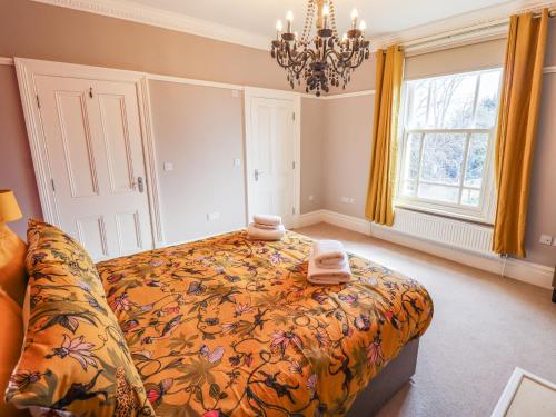 a bedroom with a bed and a chandelier at 105 Spilsby Road in Boston