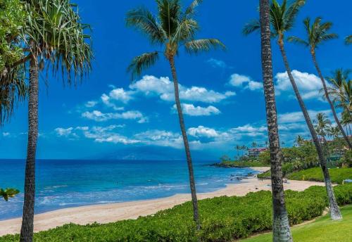 a beach with palm trees and the ocean at Polo Beach Club Two Bedrooms - Sleeps 6 by Coldwell Banker Island Vacations in Wailea