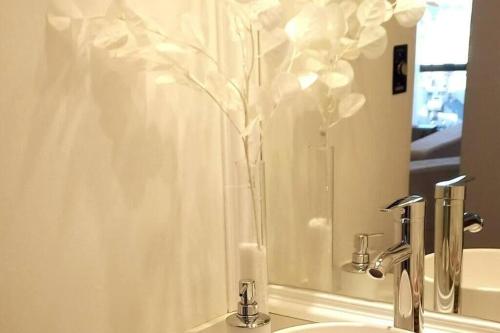 Un baño con un jarrón con una flor. en Departamento un dormitorio Ubicación ideal Córdoba en Córdoba