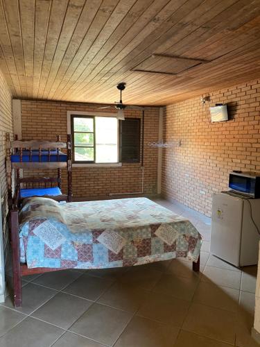 a bedroom with a bed in a brick wall at Flat Trindade in Trindade