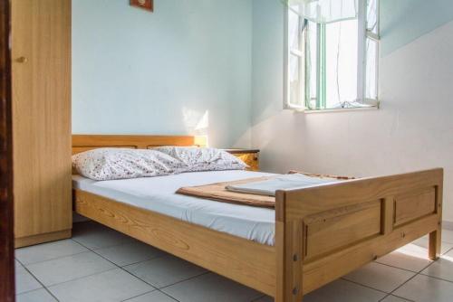 ein Schlafzimmer mit einem Holzbett und einem Fenster in der Unterkunft Secluded fisherman's cottage Cove Zizanj, Pasman - 21004 in Tkon