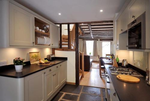 a kitchen with white cabinets and a counter top at No 2 The Forge Coniston in Coniston