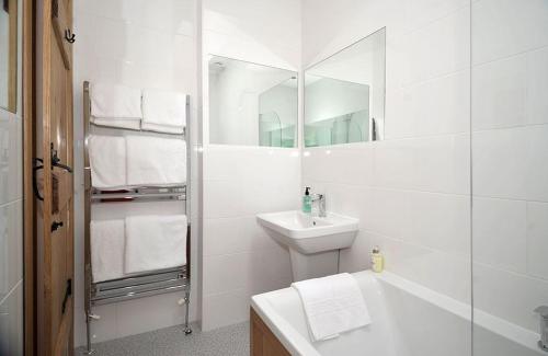 a white bathroom with a sink and a mirror at No 2 The Forge Coniston in Coniston