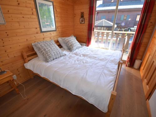 Ce lit se trouve dans une chambre en bois dotée d'une fenêtre. dans l'établissement Appartement Centre Les Gets, Pied des Pistes, Belle Terrasse, 2 Ch, 1 Cabine, 6/8 Couchages - FR-1-623-99, aux Gets