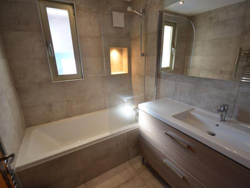 une salle de bain avec une baignoire, un lavabo et un miroir dans l'établissement Appartement Centre Les Gets, Pied des Pistes, Belle Terrasse, 2 Ch, 1 Cabine, 6/8 Couchages - FR-1-623-99, aux Gets