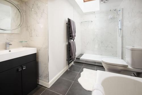y baño con lavabo, aseo y ducha. en Westwood Cottage en Longniddry