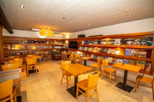 a restaurant with tables and chairs in a library at Hotel Cumbres del Sur in Puc&oacute;n