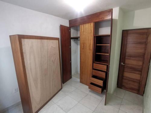 Cette chambre dispose de deux portes en bois et d'un placard. dans l'établissement Villa el roble, à Acapulco
